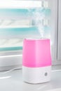 Pink ultrasonic humidifier on a window moistens dry air Royalty Free Stock Photo