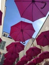 Pink umbrella suspended in the street in Rueil Malmaison