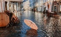 Pink umbrella on wet pavement at Autumn evening in Tallinn old town ,yellow leaves fall blurred city light ,rainy season