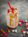 Pink unicorn milkshake with whipped cream, dripping sauce and candy