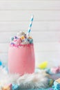 Pink Unicorn strawberry milkshake with whipped cream, sugar and colorful confetti