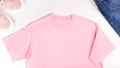 Pink unisex t shirt mock up flat lay on white background. Top front view t-shirt, snikers, jeans and copy space. Mockup tshirt Royalty Free Stock Photo