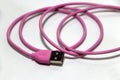 Pink used USB plug with cable on the white background. Royalty Free Stock Photo