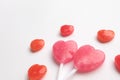 Pink Valentine`s day heart shape lollipop with small red candy in cute pattern on empty white paper background. Love Concept. Min Royalty Free Stock Photo