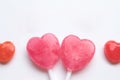 Pink Valentine`s day heart shape lollipop small red candy in cute pattern on empty white paper background. love concept. top view. Royalty Free Stock Photo