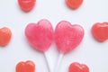 Pink Valentine`s day heart shape lollipop small red candy in cute pattern on empty white paper background. love concept. top view. Royalty Free Stock Photo