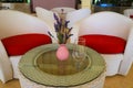 Pink vase with a summer bouquet of lavender flowers on a glass table with a transparent glass against the background of white red Royalty Free Stock Photo