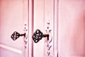Pink vintage antique doors with old skeleton keys in lock wooden background texture, retro design