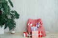 Pink vintage chair with gifts in the interior of the gray room Royalty Free Stock Photo
