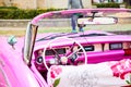 Pink vintage classic interior of American car parked on the street of Old Havana, Cuba Royalty Free Stock Photo