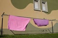 Pink and violet bed sheets hanging on a drying rack in the garden Pesaro, Italy Royalty Free Stock Photo