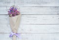 Dried flower bouquet in brown paper on wood background. Royalty Free Stock Photo