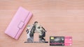 Pink wallet, house dollar symbol and credit card on a wooden background