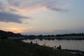 Pink warm landscape sunset over the river fishermen are standing and fishing Royalty Free Stock Photo