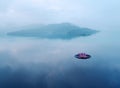 A pink water lily blooming on an infinity pool with foggy mountains in background under moody cloudy sky in a peaceful Zen atmosph Royalty Free Stock Photo