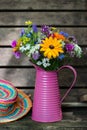 Pink watering can with wild summer flowers Royalty Free Stock Photo