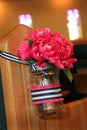 Pink Wedding Flowers in Mason Jar Hanging from Church Pew Royalty Free Stock Photo