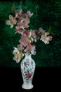 Pink and White Artificial Flowers in a Glazed Decorated Flower Vase on a Wooden Table with Mottled Background Royalty Free Stock Photo