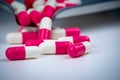 Pink-white capsule pills on stainless steel drug tray. Pharmacy drugstore. Pharmaceutics concept. Pharmaceutical industry.