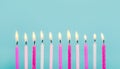 11 pink and white color birthday candles burning in a row isolated on blue. Happy Birthday card design concept. Royalty Free Stock Photo