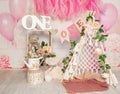 pink and white decoration for a 1st birthday cake smash studio photo shoot with balloons, paper decor, cake and topper Royalty Free Stock Photo