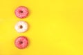 Pink and white donuts on yellow backdrop with copyspace