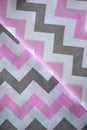 Pink, white and grey chevron pattern fabric sample. Fabric background