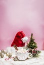 Pink white mug with marshmallows, Christmas tree, ornaments and Santa Claus hat on a marble and pink background Royalty Free Stock Photo