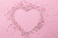 Pink and white pearly cake sprinkles shaped in a heart shape with empty space for text in the centre - Sprinkles on pink Royalty Free Stock Photo