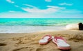 Pink and white sandals on sand beach. Casual style flip-flop were removed at seaside. Summer vacation on tropical beach. Fun Royalty Free Stock Photo