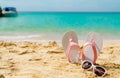 Pink and white sandals, sunglasses on sand beach at seaside. Casual fashion style flipflop and glasses at seashore. Summer Royalty Free Stock Photo