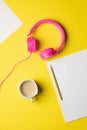 pink wired headphones with several blank sheets of paper, a pencil and a coffee Royalty Free Stock Photo