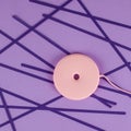 Pink wireless charger for cell phone on purple background with paper stripes Royalty Free Stock Photo