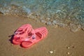 Pink Women`s JELLY SANDALS on a sea shore. LADIES FLAT JELLIES SUMMER BEACH SHOES.