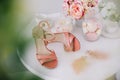 Pink women shoes, a bouquet of spring flowers and marshmallows on white background. Morning of the bride. Royalty Free Stock Photo