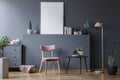 Pink wooden chair at black table in grey living room interior with mockup of empty poster