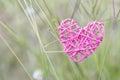 Pink wooden heart over blurred green grass flower background Royalty Free Stock Photo