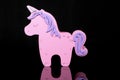 pink toy unicorn of a child on a dark background