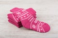 Pink woolen socks on white wooden background