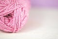 Pink yarn / wool on soft focus background.