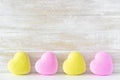 Pink and yellow bath bombs in shape of heart on rustic wooden background. Royalty Free Stock Photo