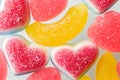 Pink and yellow chewy candies in powdered sugar, gelatin sweets close-up