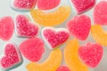 Pink and yellow chewy candies in powdered sugar, gelatin sweets close-up