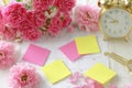 Pink and yellow flowers on a table with a clock and a calendar Royalty Free Stock Photo