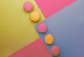 Pink yellow macaroons on yellow blue pink graphic background, neon color, place for text, creative layout, top view