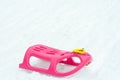 Pink and yellow plastic sleigh on for the children durrign winter Royalty Free Stock Photo