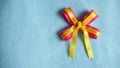 Pink and yellow ribbon on blue fabric background Royalty Free Stock Photo