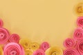 Pink and yellow rose flat lay background with crafted paper flowers at bottom and empty light yellow copy space Royalty Free Stock Photo