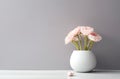 Pink and yellow roses in Modern white vase on white table beside classic armchair. Created with Generative AI technology Royalty Free Stock Photo