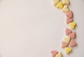 Pink and yellow Vitamins in the shape of a heart lie on a white background